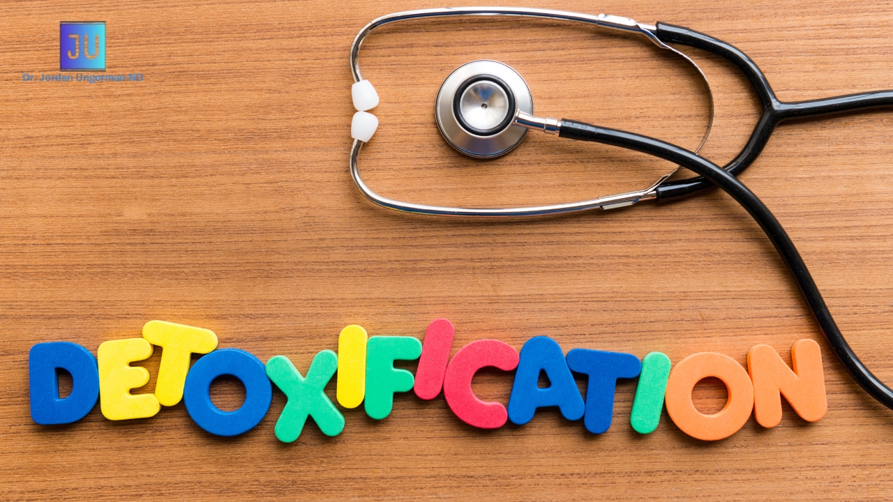 A Stethoscope On a table and Colorful letters are used to write the word Detoxifications. The image is Aimed to Show the process of Detoxification protocols for modern lifestyles.