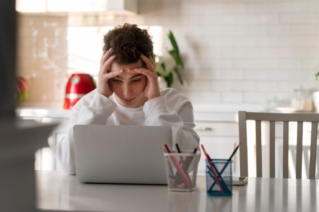 A Man with chronic fatigue sitting in front of a laptop. Will discuss integrative approaches to chronic fatigue.